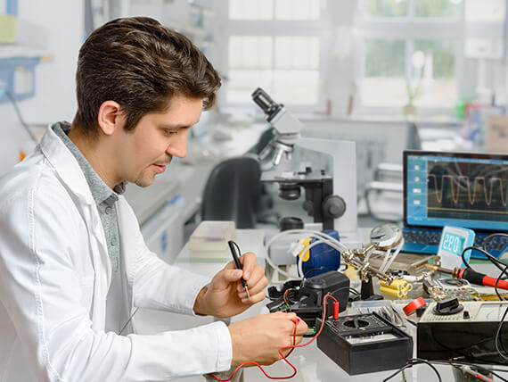 Young engineer works with electronic equipment in research facility